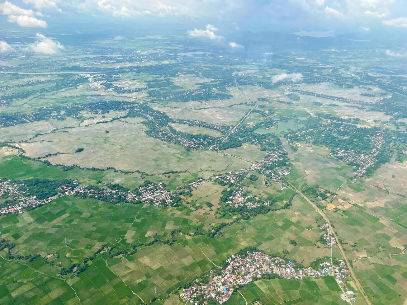 il paesaggio aereo mostra una veduta verde della città. strade, risaie e case di paese. foto