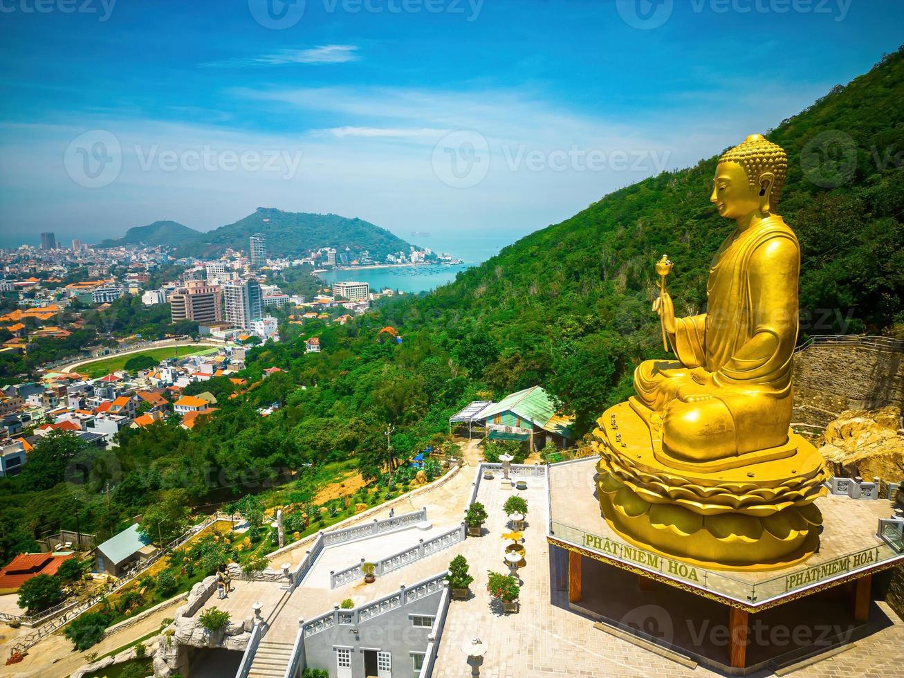 ariel vista la mano della statua del buddha d'oro che tiene il loto al monastero di chon khong che attira i turisti a visitare spiritualmente nei fine settimana a vung tau, vietnam. concetto di viaggio. foto