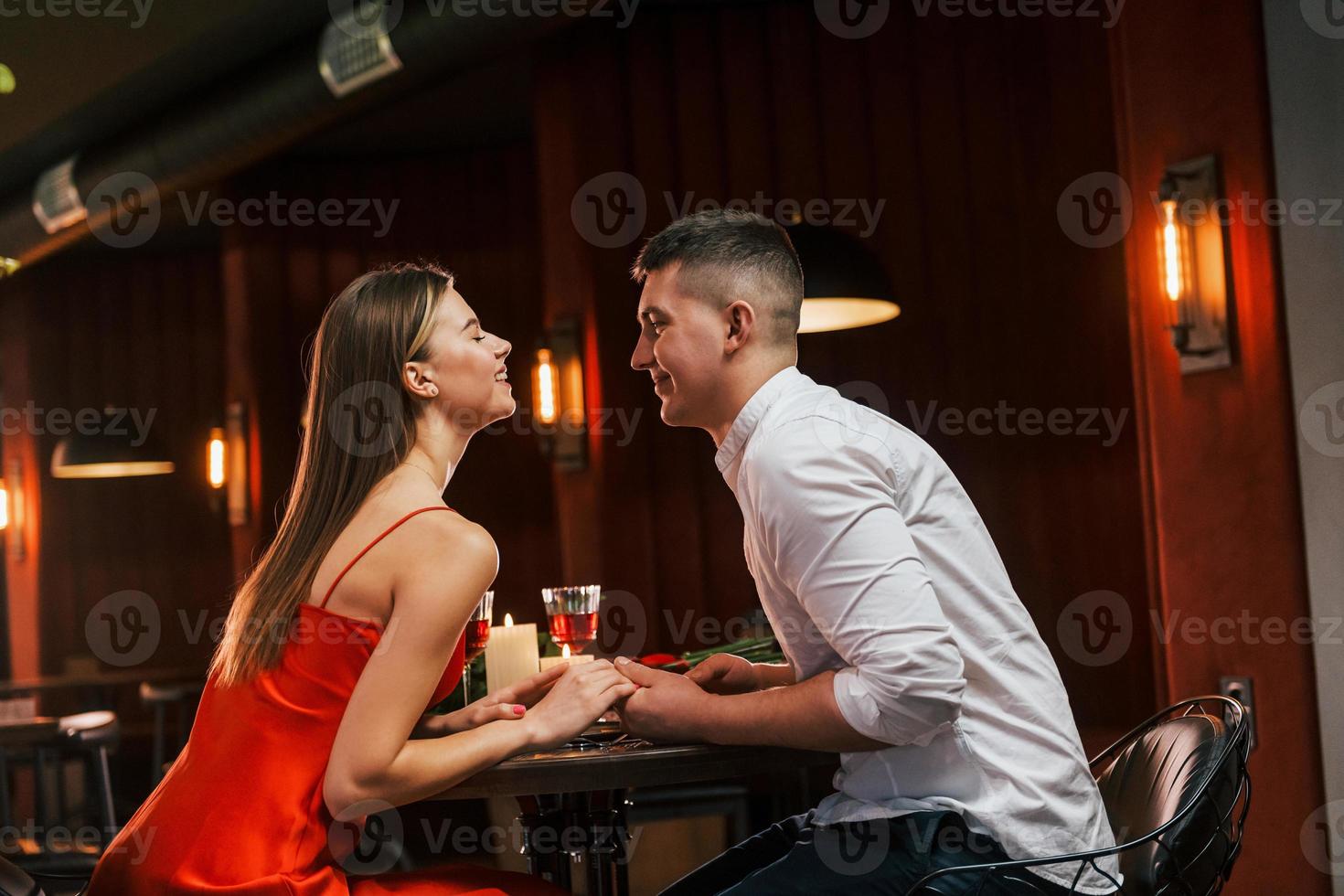 vista laterale. le coppie romantiche cenano nel ristorante foto