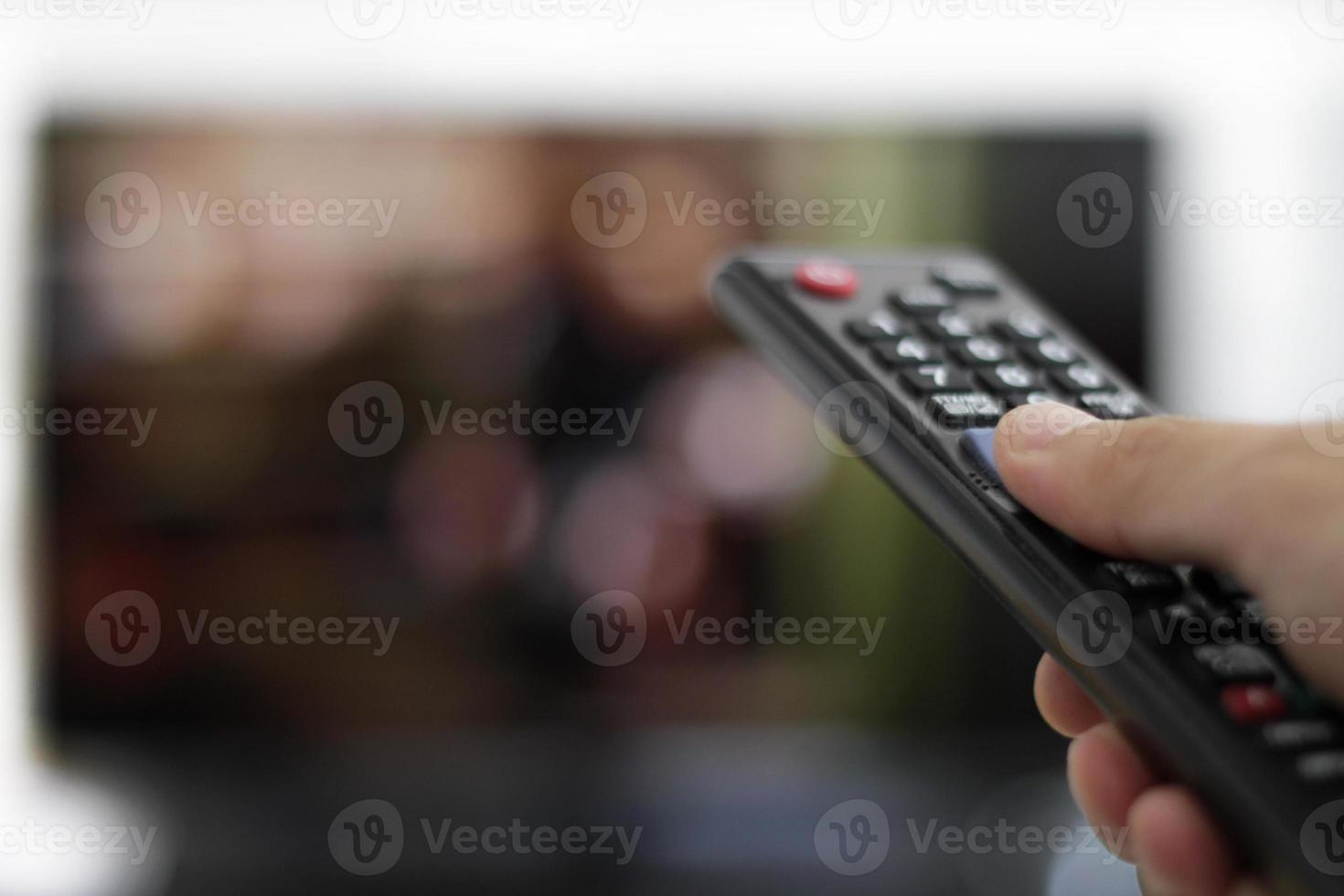 telecomando e schermo - abbuffarsi di guardare il programma televisivo preferito foto