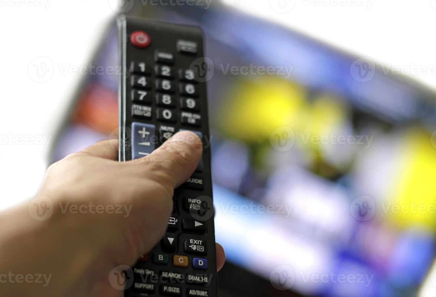 telecomando e schermo - abbuffarsi di guardare il programma televisivo preferito foto