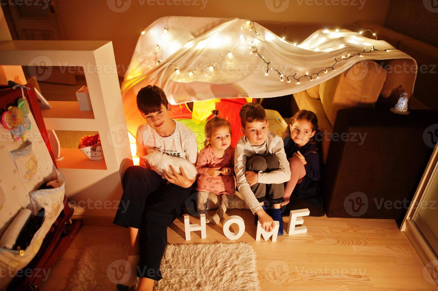 giocare ai bambini con il gattino in tenda di notte a casa. umore hygge. foto