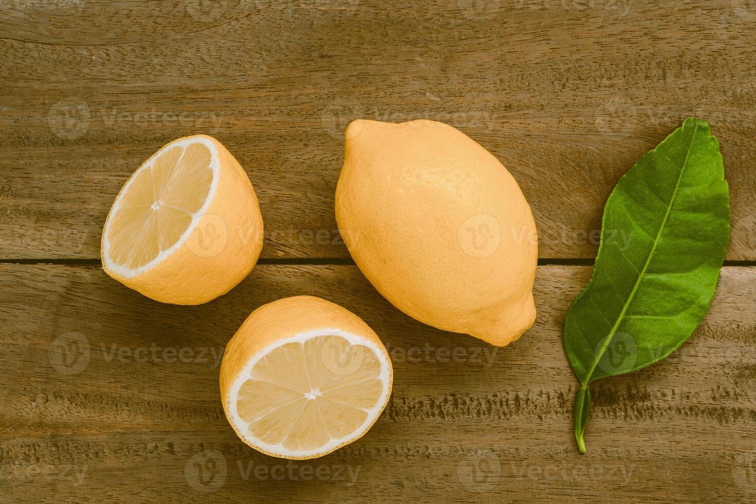 limoni freschi e foglie di limoni su fondo di legno rustico. limoni freschi  e fetta di limone su tavola di legno con disposizione piatta. sfondo di  agrumi freschi. 8376382 Stock Photo su