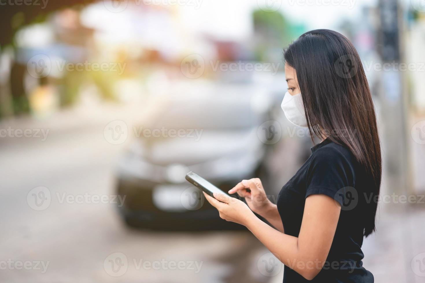 donna in piedi per strada utilizzando lo smartphone foto