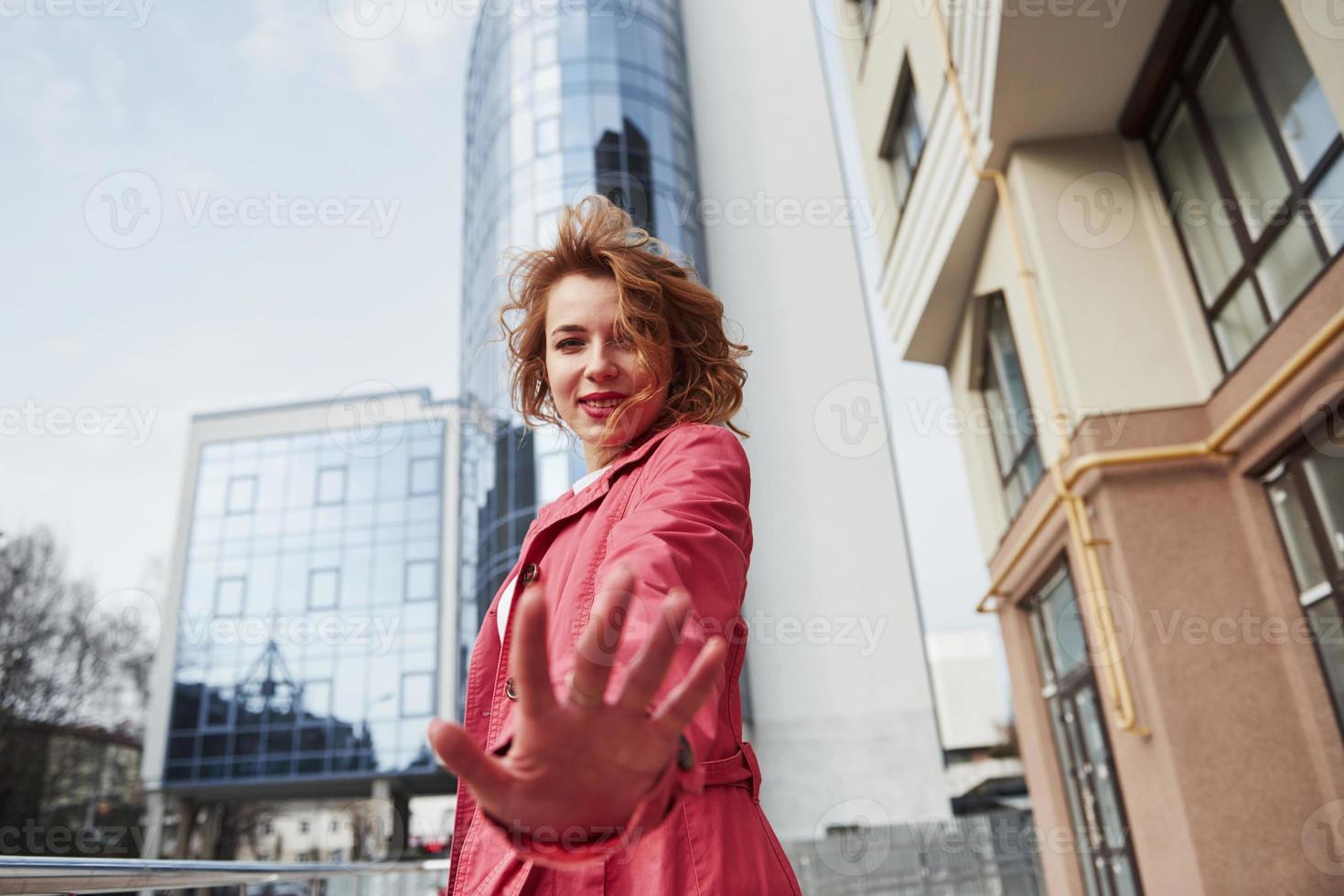 A presto. una bella donna adulta con un caldo cappotto rosso ha camminato in città durante i fine settimana foto