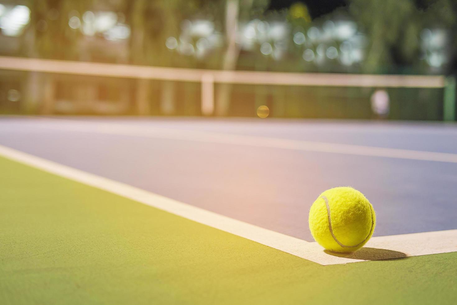 pallina da tennis sulla linea d'angolo del campo duro foto