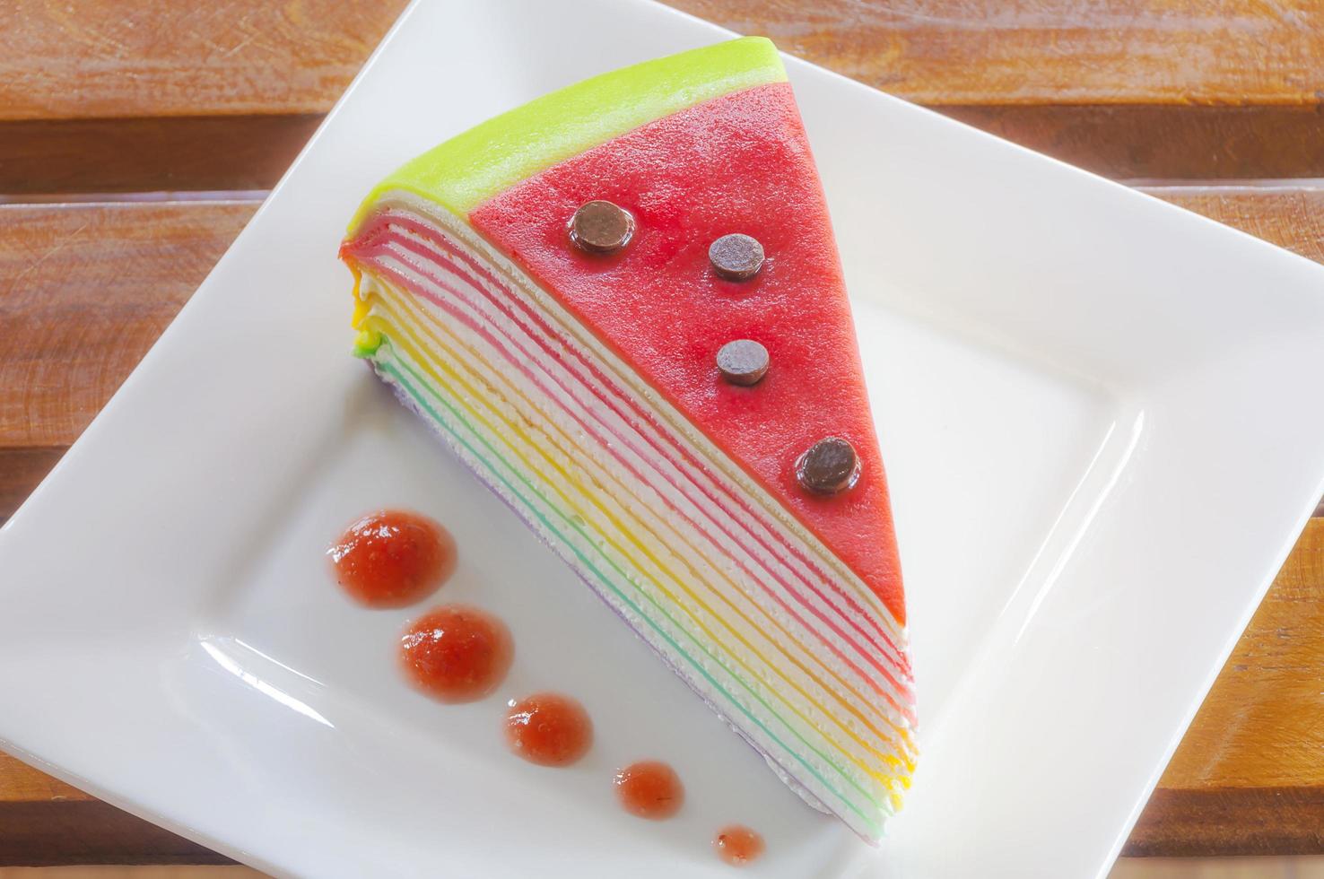 torta di crepe arcobaleno su un piatto bianco foto