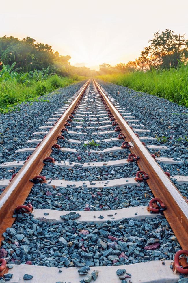 binario ferroviario con luce solare davanti foto