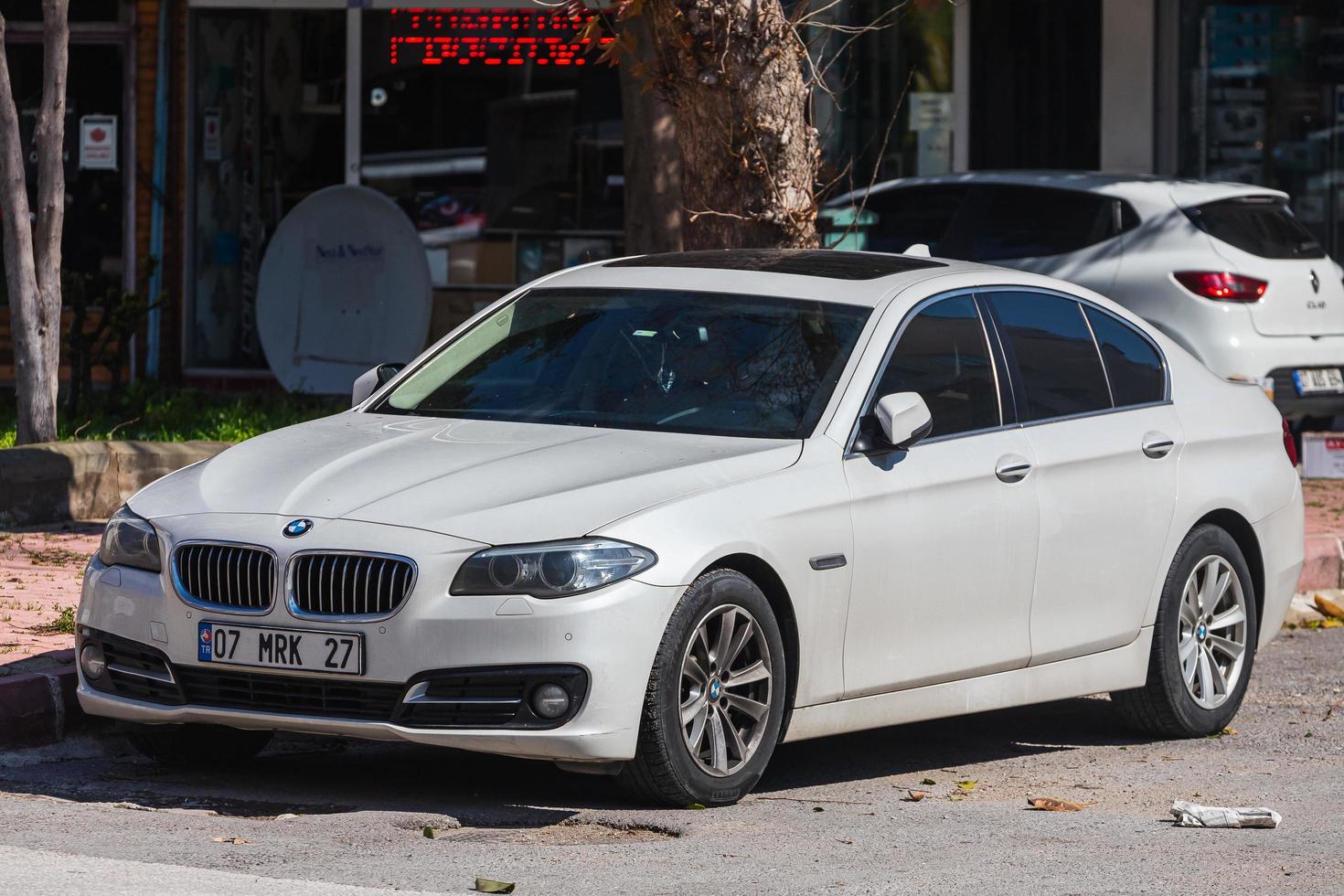 antalya turchia marzo 04 2022 bianco bmw serie 5 è parcheggiato sulla strada in una calda giornata autunnale foto