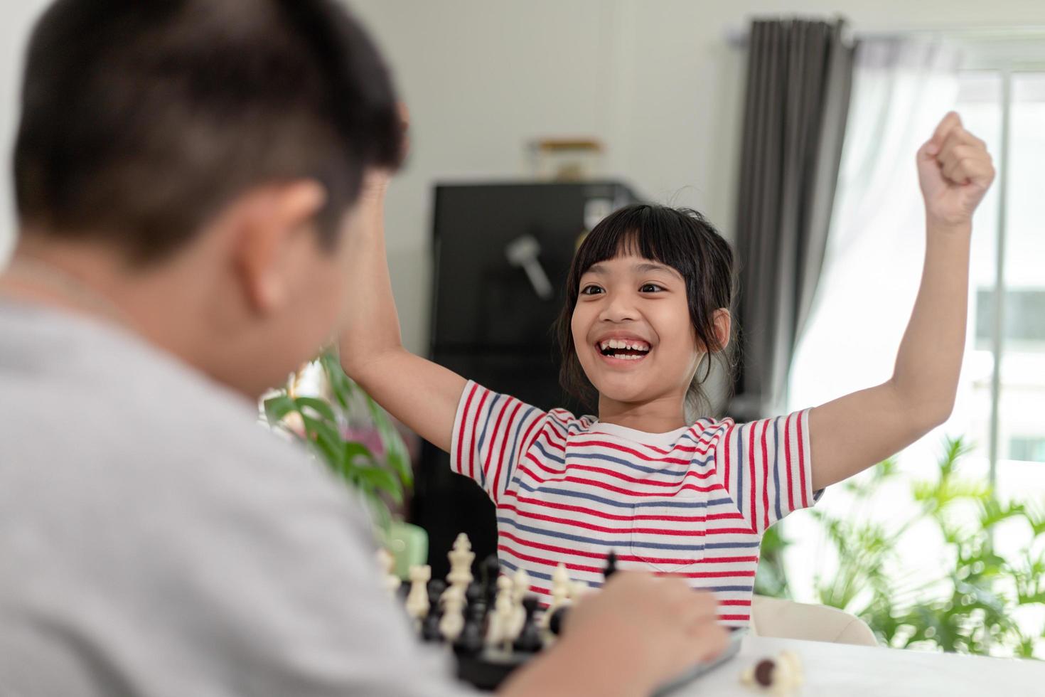 il ragazzino e la bambina stanno giocando a scacchi a casa. bambini che giocano a scacchi foto