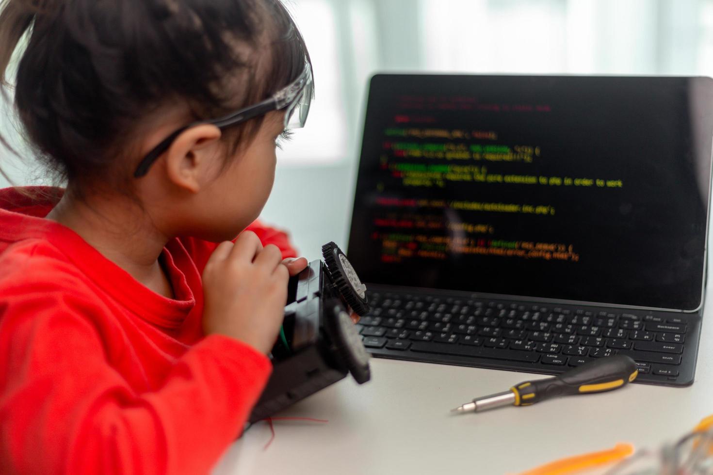 gli studenti asiatici imparano a casa a codificare auto robot e cavi di schede elettroniche in stelo, vapore, matematica ingegneria scienza tecnologia codice informatico in robotica per bambini concetto. foto