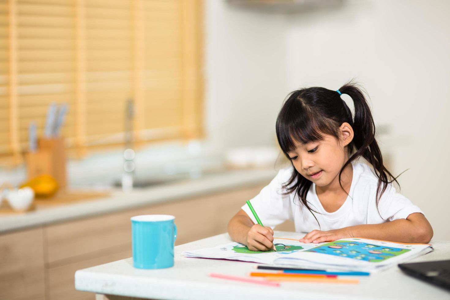 covid-19 coronavirus e apprendimento da casa, concetto di bambino a scuola a casa. i bambini piccoli studiano online imparando da casa con il laptop. foto