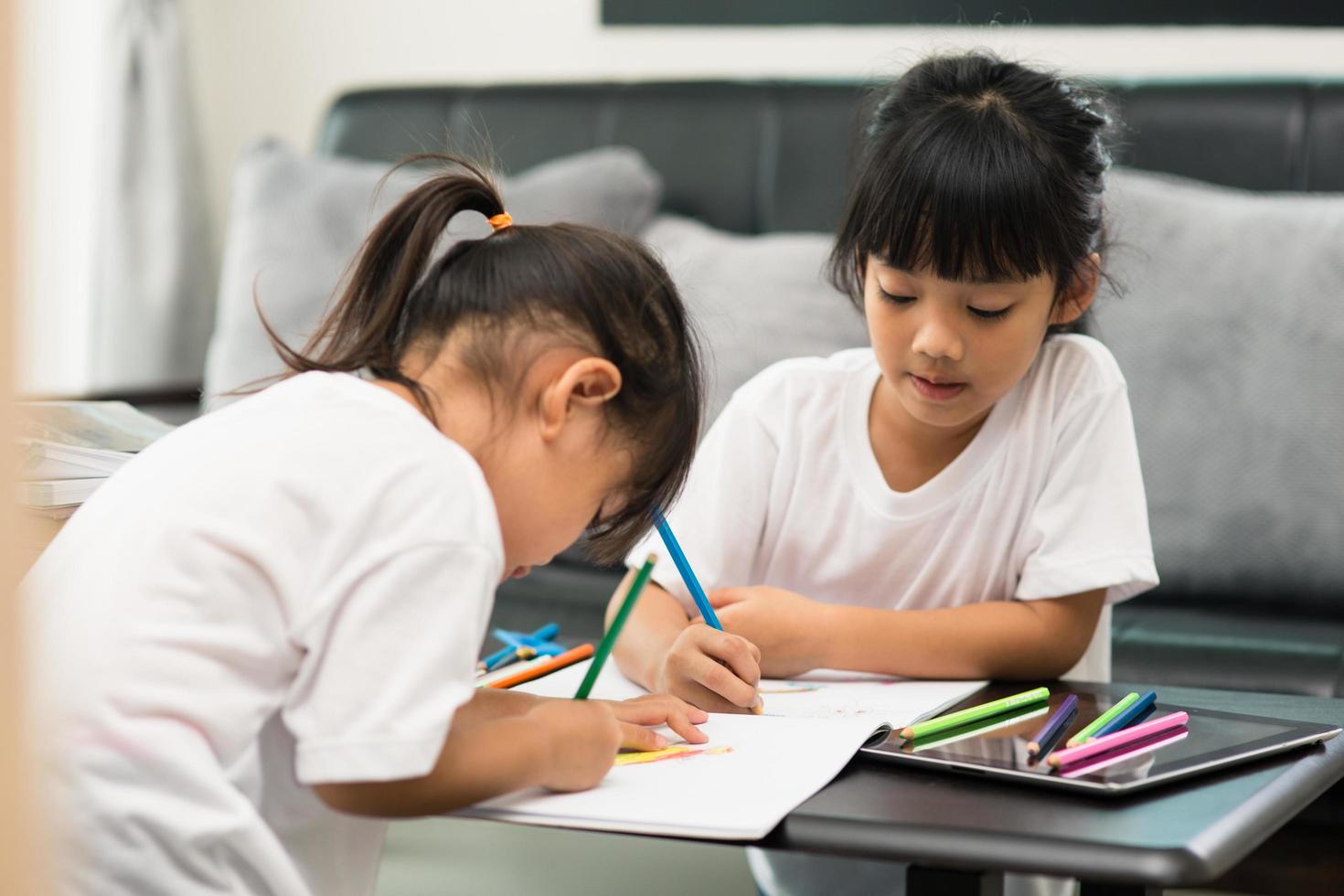 covid-19 coronavirus e apprendimento da casa, concetto di bambino a scuola a casa. i bambini piccoli studiano online imparando da casa con il laptop. foto