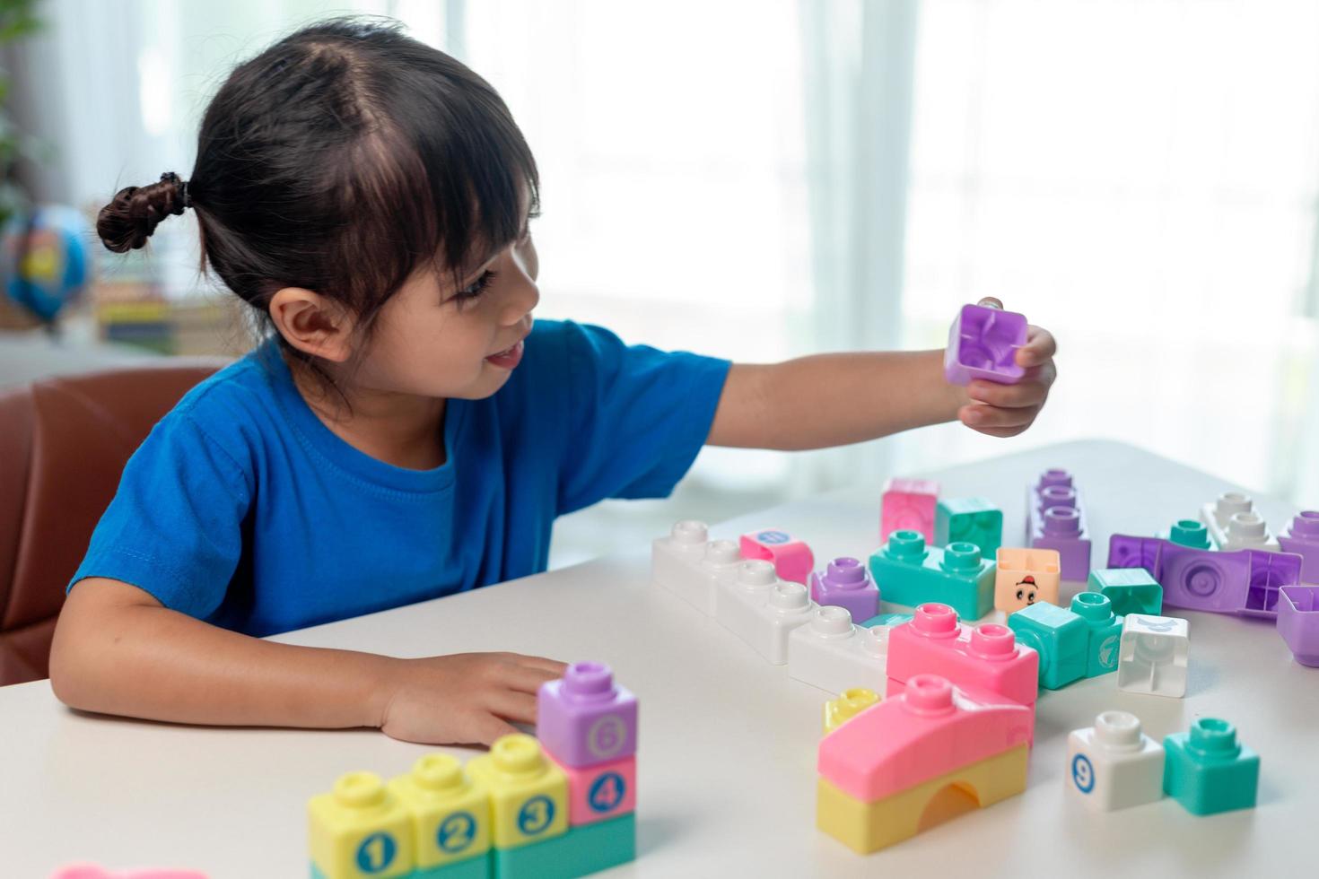 ragazza asiatica del bambino che gioca i blocchi creativi del giocattolo per homeschooling foto