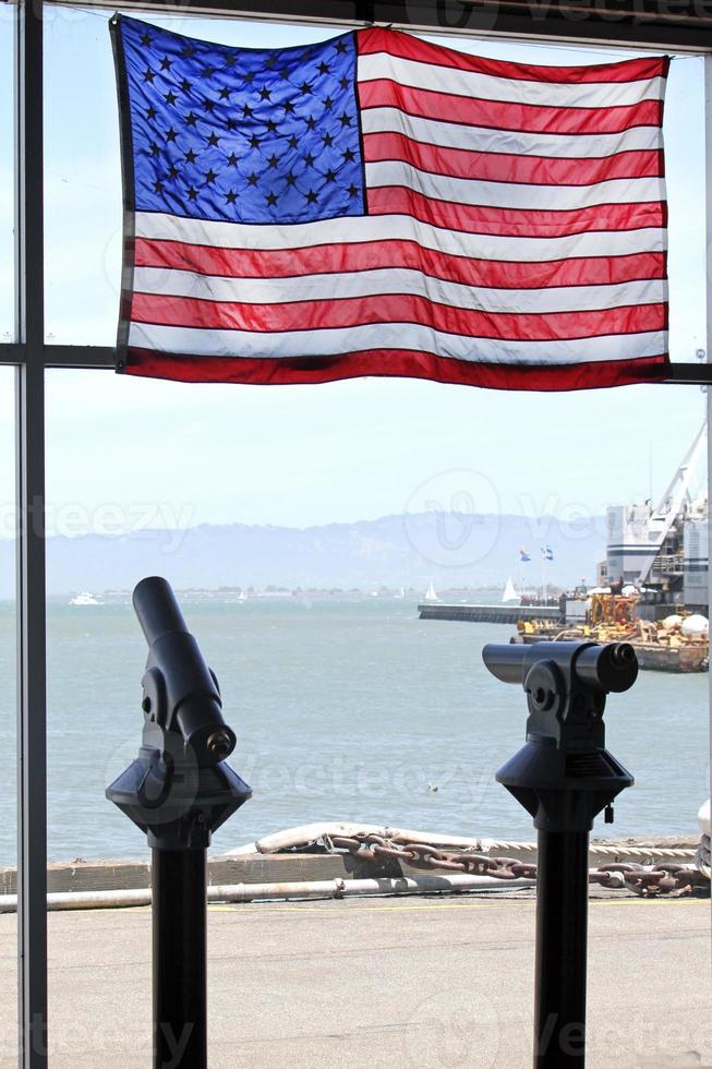 bandiera americana e due telescopi nella baia di san francisco foto