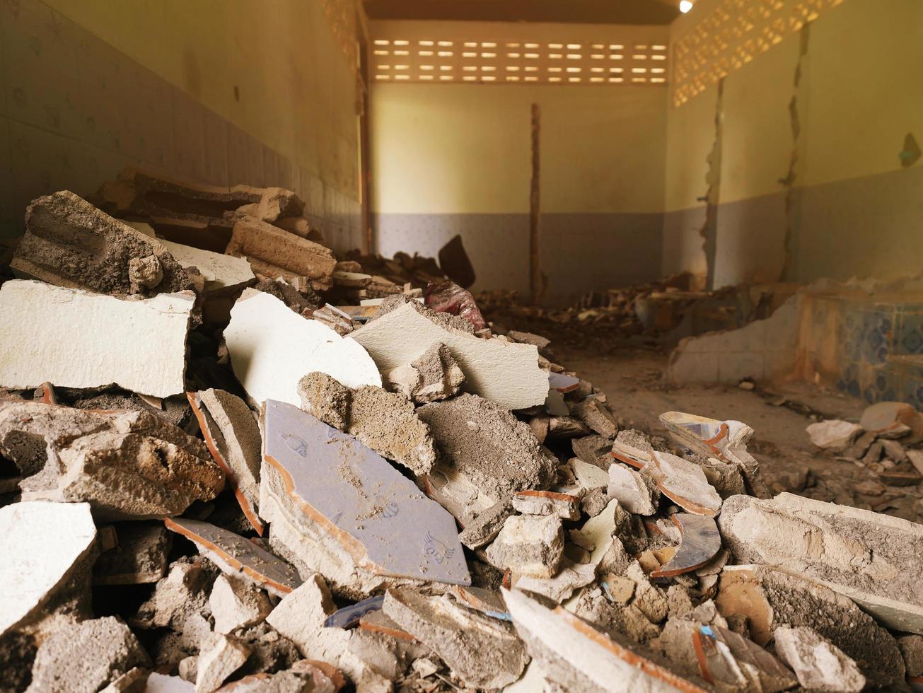 primo piano delle macerie di un edificio industriale che crolla in un mucchio di cemento e mattoni. e i detriti frastagliati causati dal fallimento degli ingegneri nella costruzione abbandonata. foto