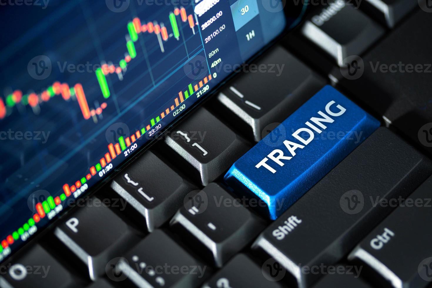 schermata del grafico del mercato azionario sulla tastiera del computer e pulsante di trading blu, concetto di investimento online foto