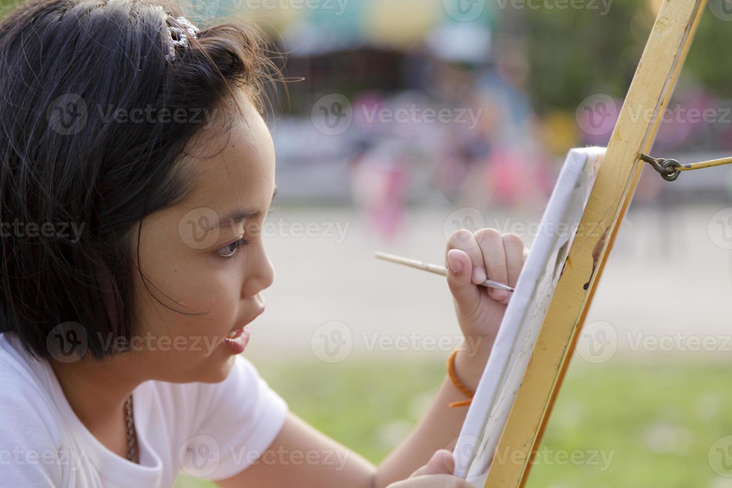 bambina asiatica che dipinge nel parco foto