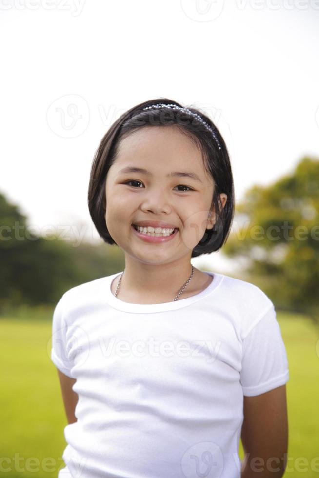 la ragazza asiatica si rilassa e sorride felicemente nel parco foto