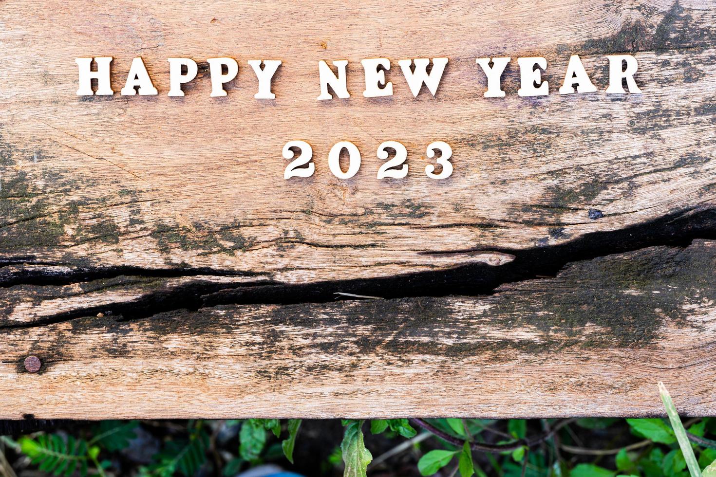 felice anno nuovo 2023 concetto. testo in legno sulla vecchia tavola di legno. spazio vuoto. foto