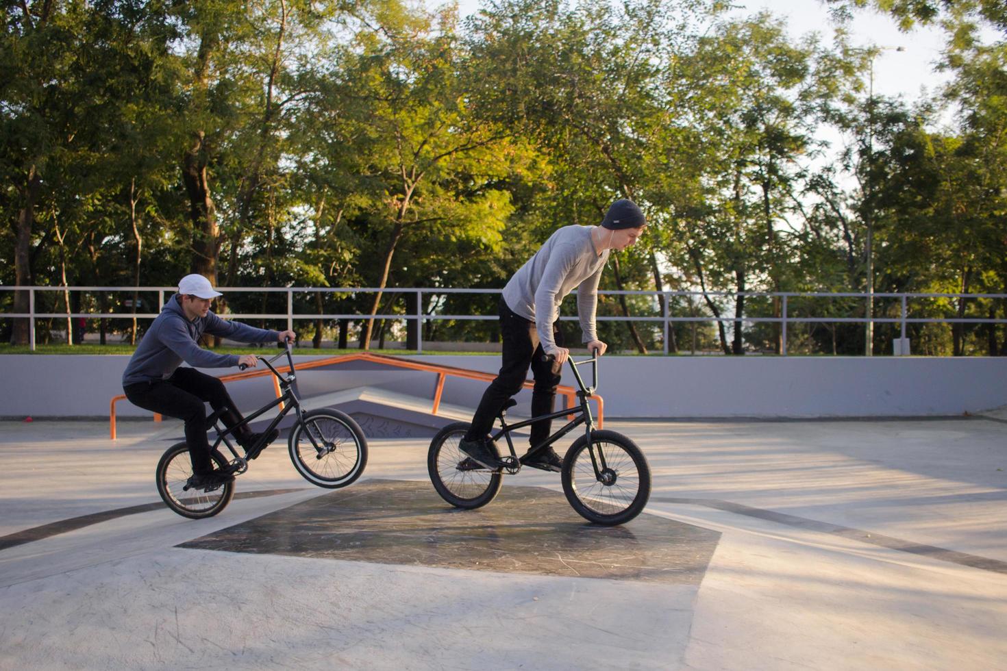 gruppo di giovani con biciclette bmx in skate plaza, ciclisti acrobatici nello skatepark foto