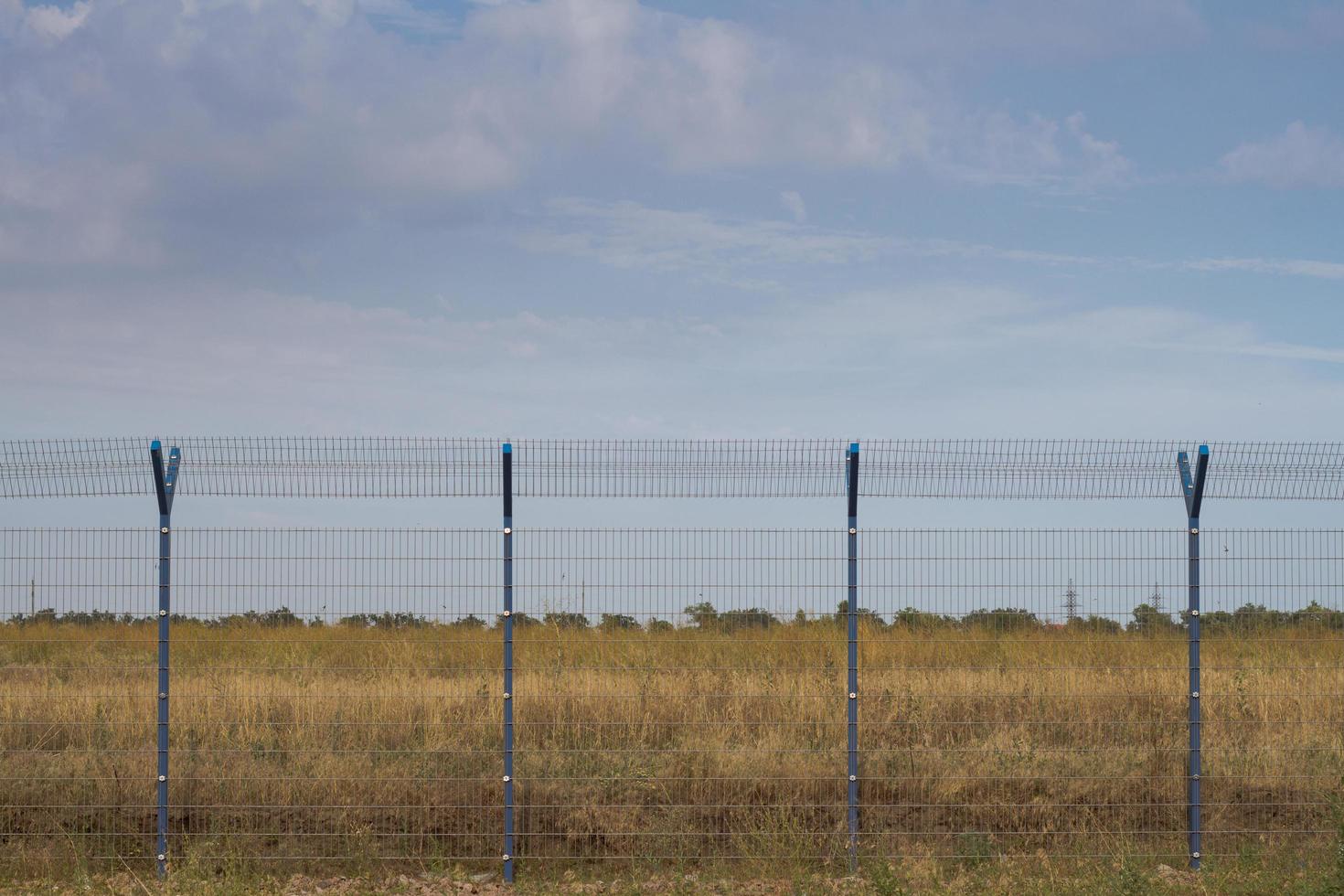 recinzione della gabbia nei campi, sfondo azzurro del cielo foto