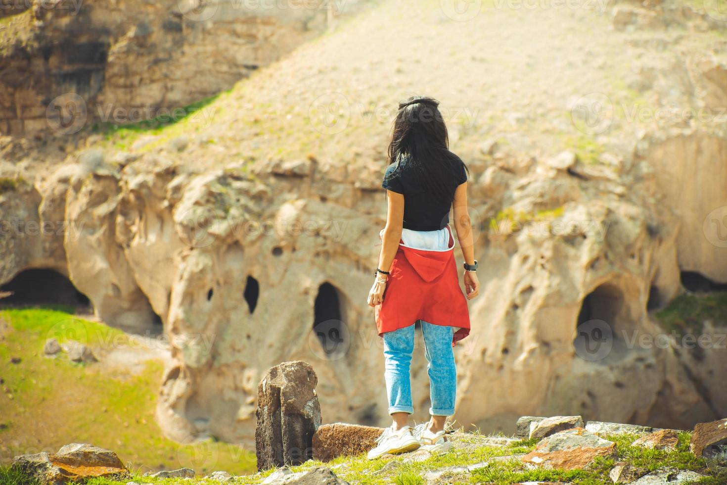 la turista femminile gode di una giornata di sole ventosa nella valle dell'orologio del sito archeologico di ani. confine con l'armenia turchia foto