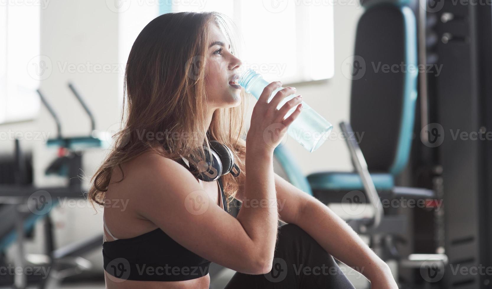 tempo di bere acqua. foto di una splendida donna bionda in palestra durante il fine settimana