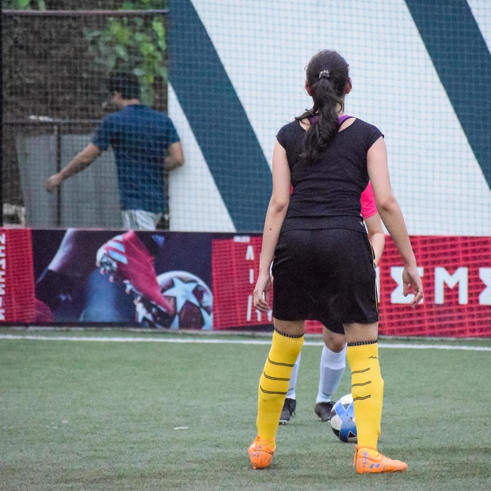 nuova delhi, india - 01 luglio 2018 - calciatrici della squadra di calcio locale durante la partita nel campionato regionale di derby su un brutto campo da calcio. momento caldo della partita di calcio sullo stadio del campo verde erba foto