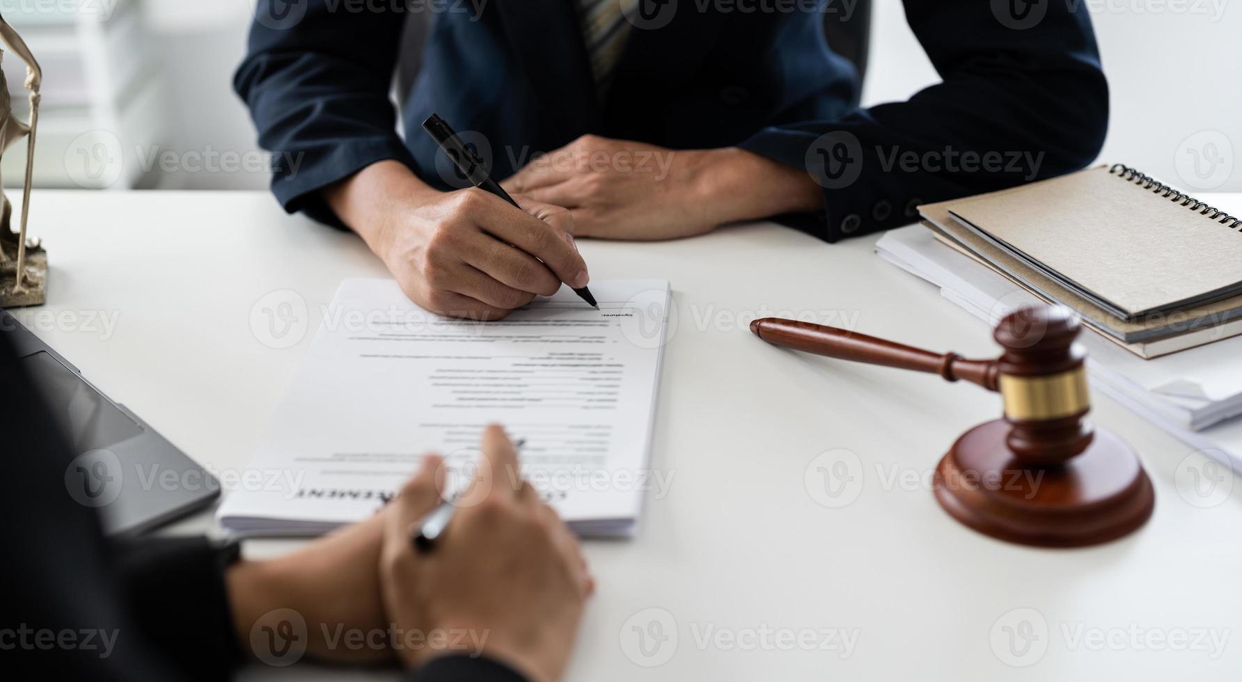segno della mano dell'uomo d'affari dopo l'avvocato che fornisce un servizio di consulenza legale presso l'ufficio con scala della giustizia e martello da martello foto
