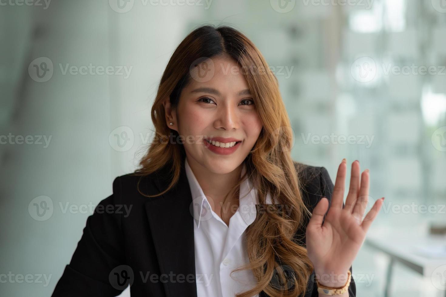 sorridente business asiatico donna faccia agitando la mano parlando con webcam, social media influencer streaming, fare videochiamate a casa. ritratto di colpo alla testa. vista webcam foto