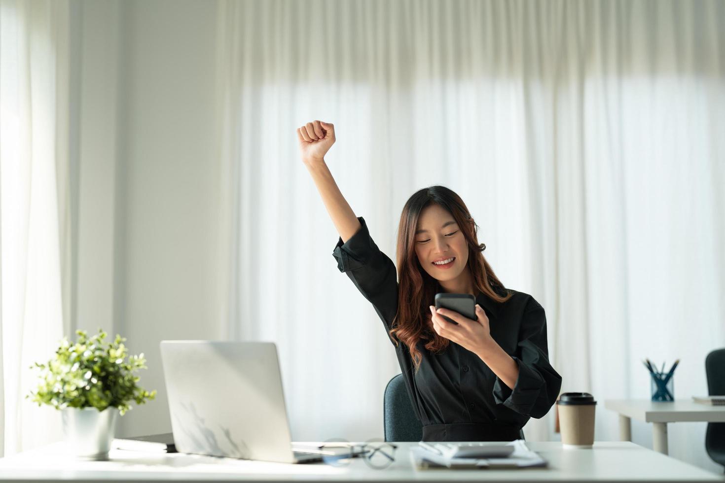 ritratto di donna asiatica felice giovane business che celebra il successo con le braccia in su. espressione positiva, successo nel concetto di business foto