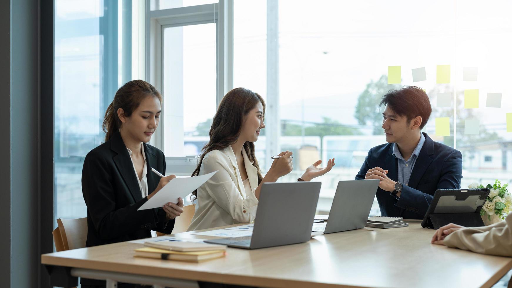 gruppo di giovani imprese asiatiche con il lavoro creativo, parlare e scambiare idee condivise durante l'incontro foto