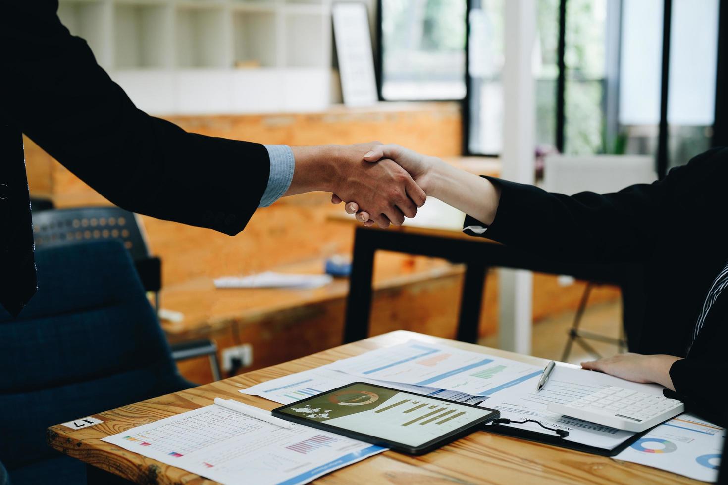 due uomini d'affari si stringono la mano dopo aver accettato insieme una proposta commerciale, una stretta di mano è un omaggio universale, spesso usato per salutare o congratularsi. foto