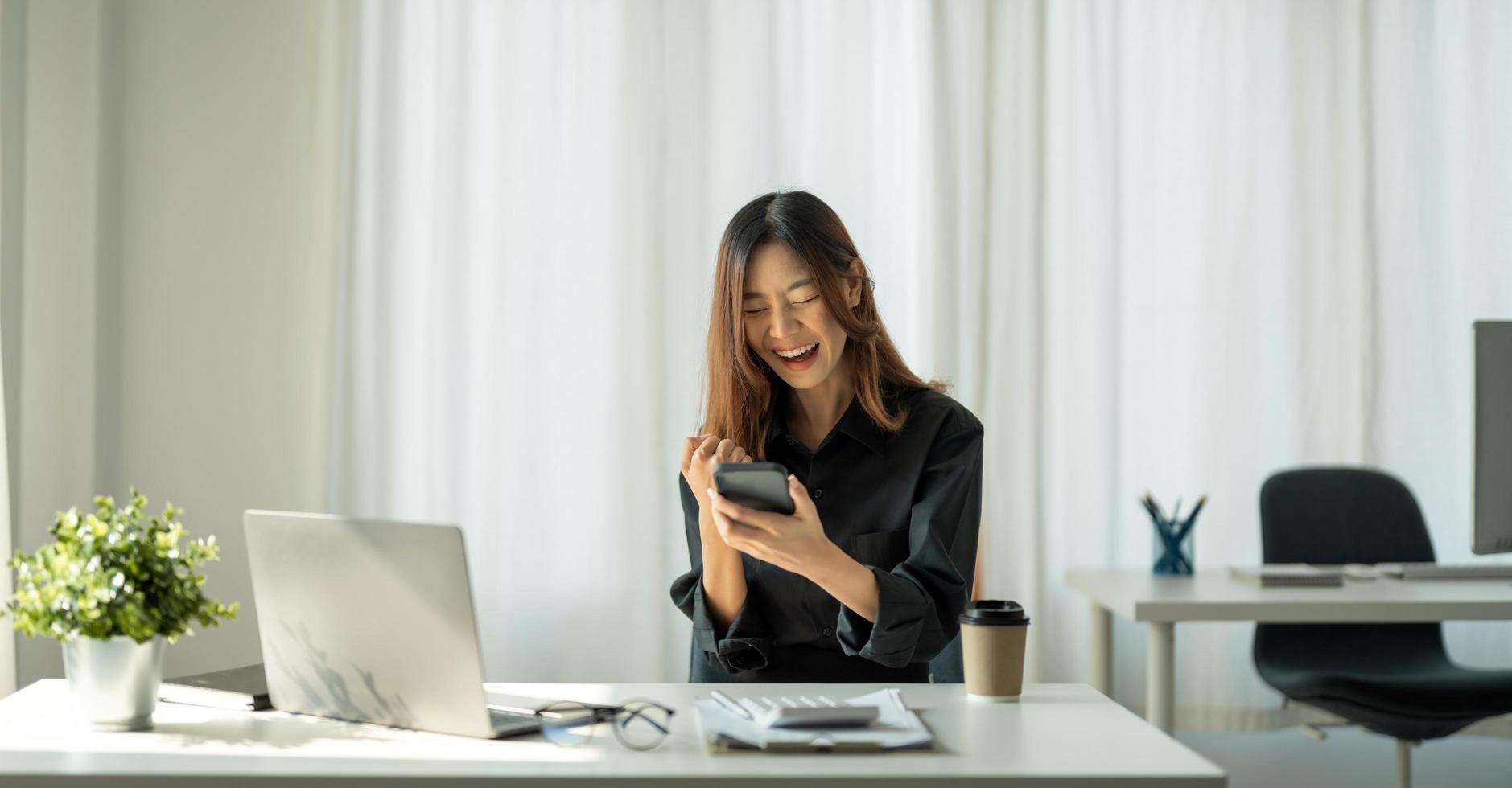 ritratto di donna asiatica felice giovane business che celebra il successo con le braccia in su. espressione positiva, successo nel concetto di business foto