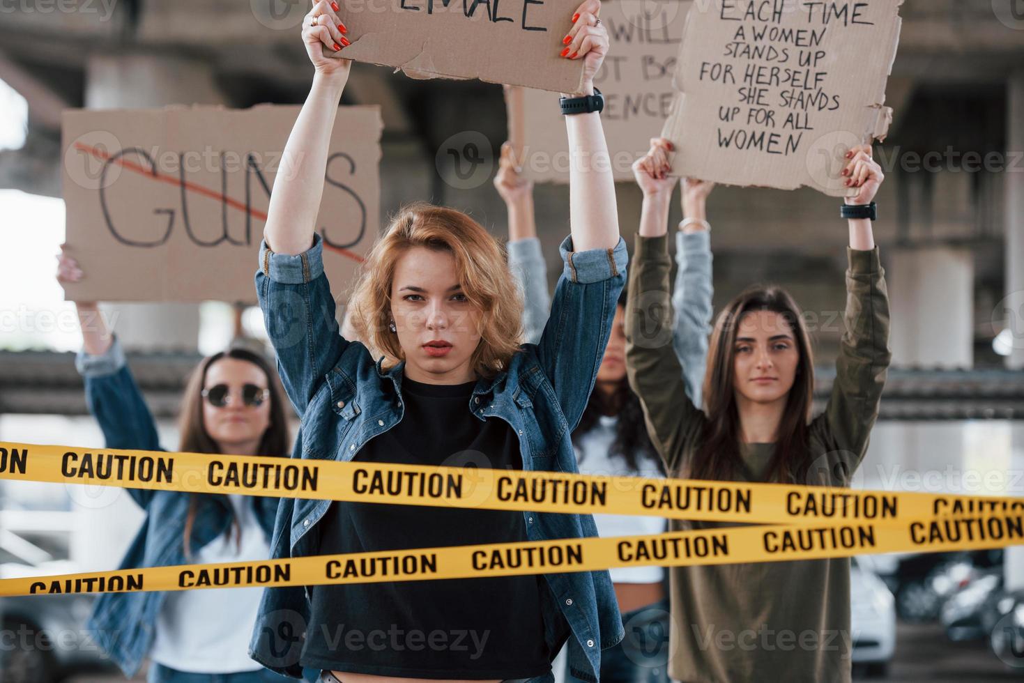 Vieni, unisciti a noi. gruppo di donne femministe protestano per i loro diritti all'aperto foto