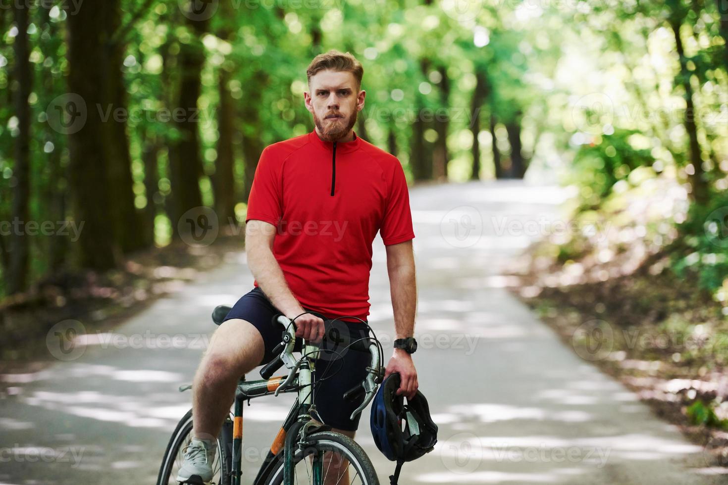 sulla strada. il ciclista in bicicletta è nella foresta in una giornata di sole foto