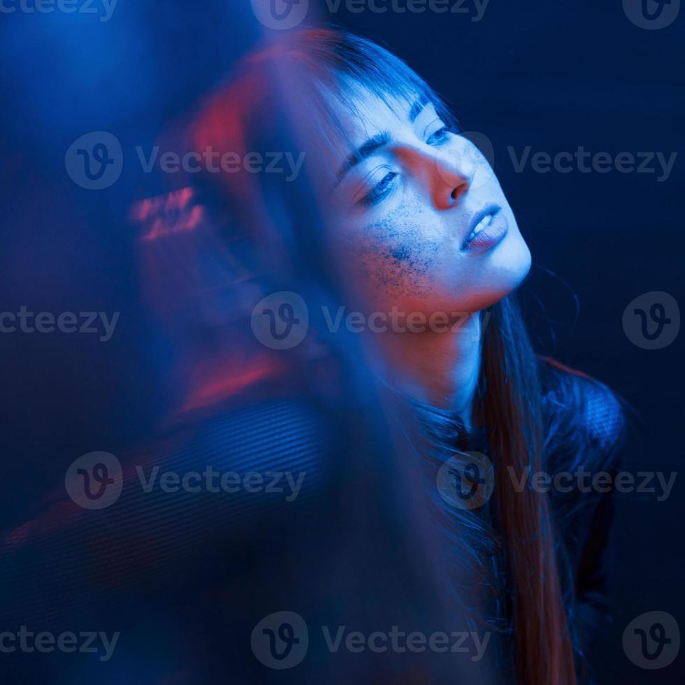sensualità e godimento. girato in studio in uno studio buio con luce al neon. ritratto di giovane ragazza foto