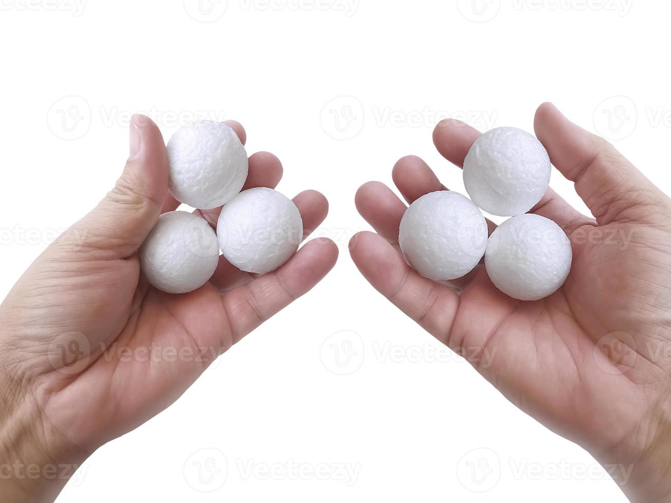 la mano dell'uomo che tiene tre palle di polistirolo in bianco bianche contro il background4 bianco foto