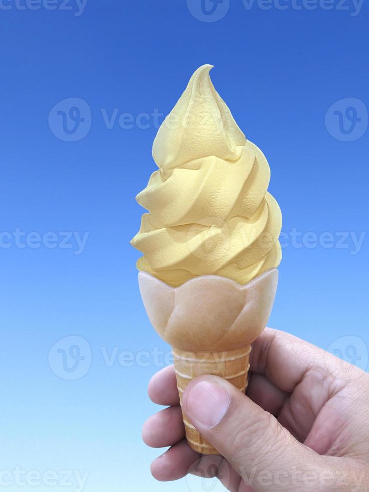 man mano che tiene un cono gelato sullo sfondo. il cielo azzurro foto