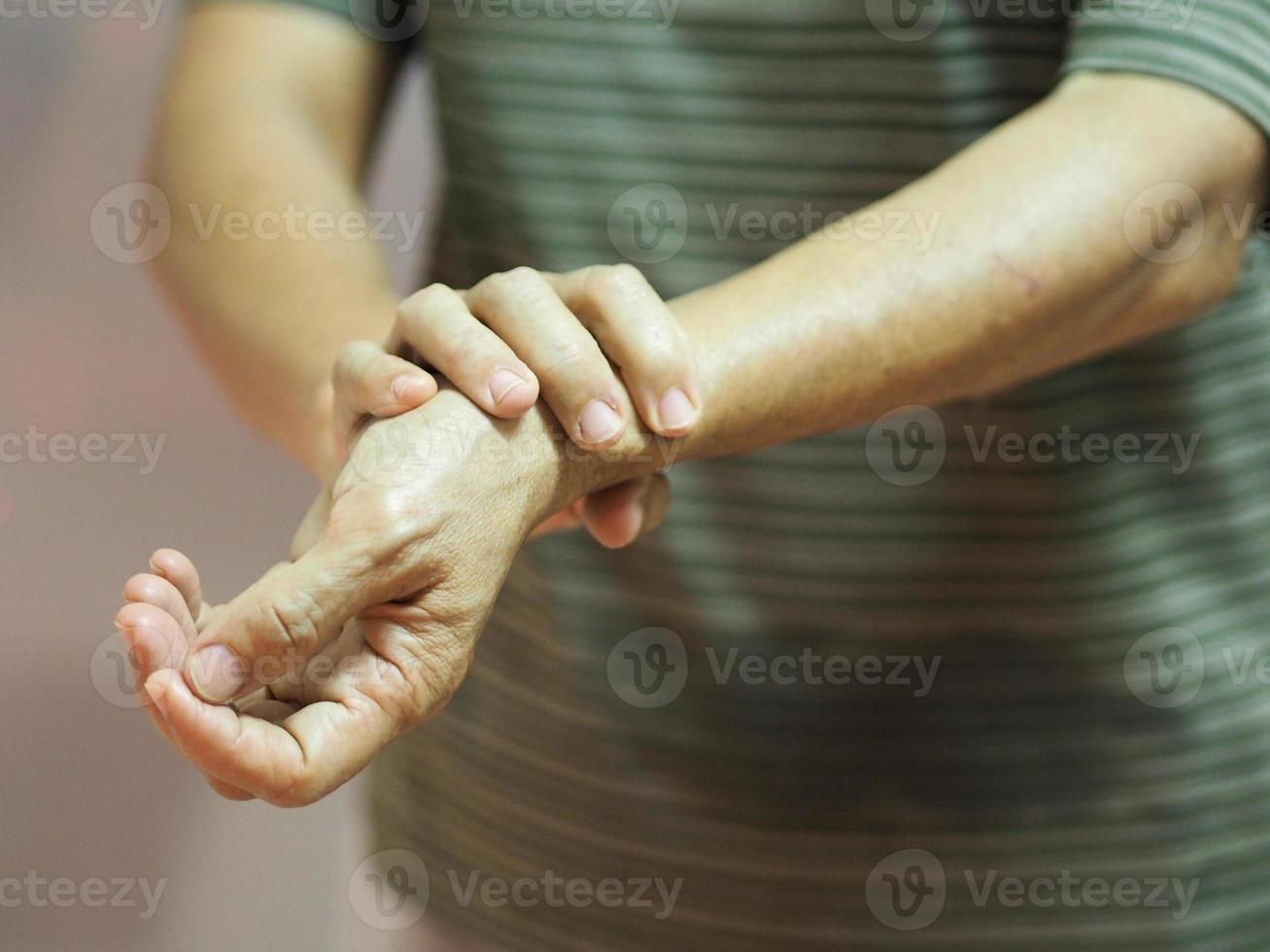 sindrome di Guillan barre, trattamento con coronavirus covid-19 vaccino, donna che si tiene per mano malattia rara il sistema immunitario del corpo attacca i nervi foto