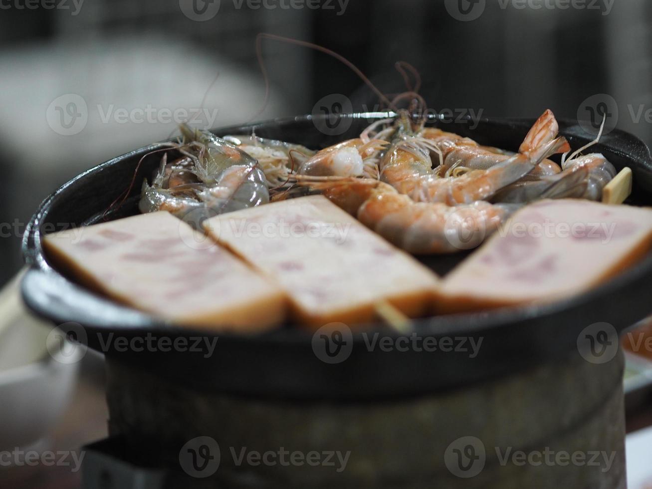 padella d'acciaio arrosto di gamberi sul fornello a carbone foto