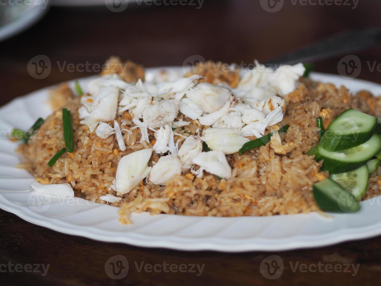 riso fritto con polpa di granchio su piatto bianco, cibo tailandese foto