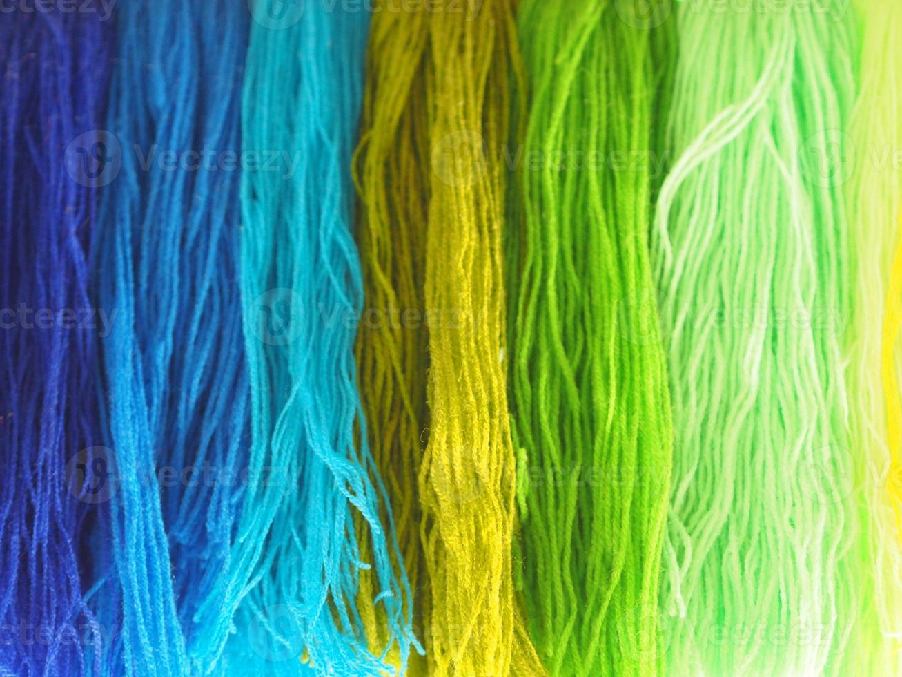 filato, garn diversi colori disposti sfumatura astratta per lo sfondo, colorato giallo verde blu viola viola oro colore scuro e morbido, tono freddo foto