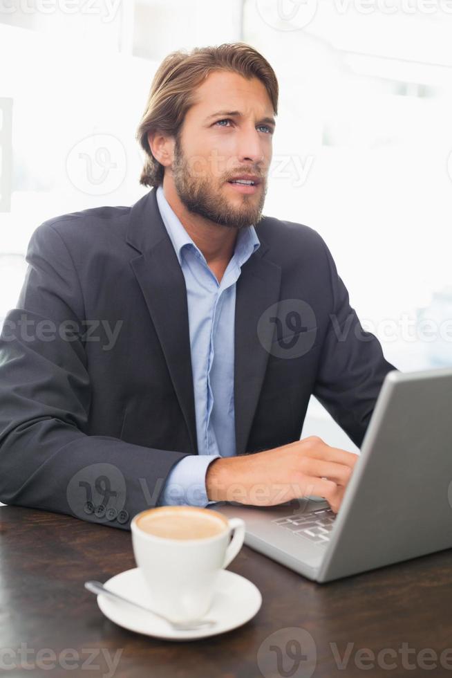 uomo d'affari, lavorando sul suo computer portatile foto