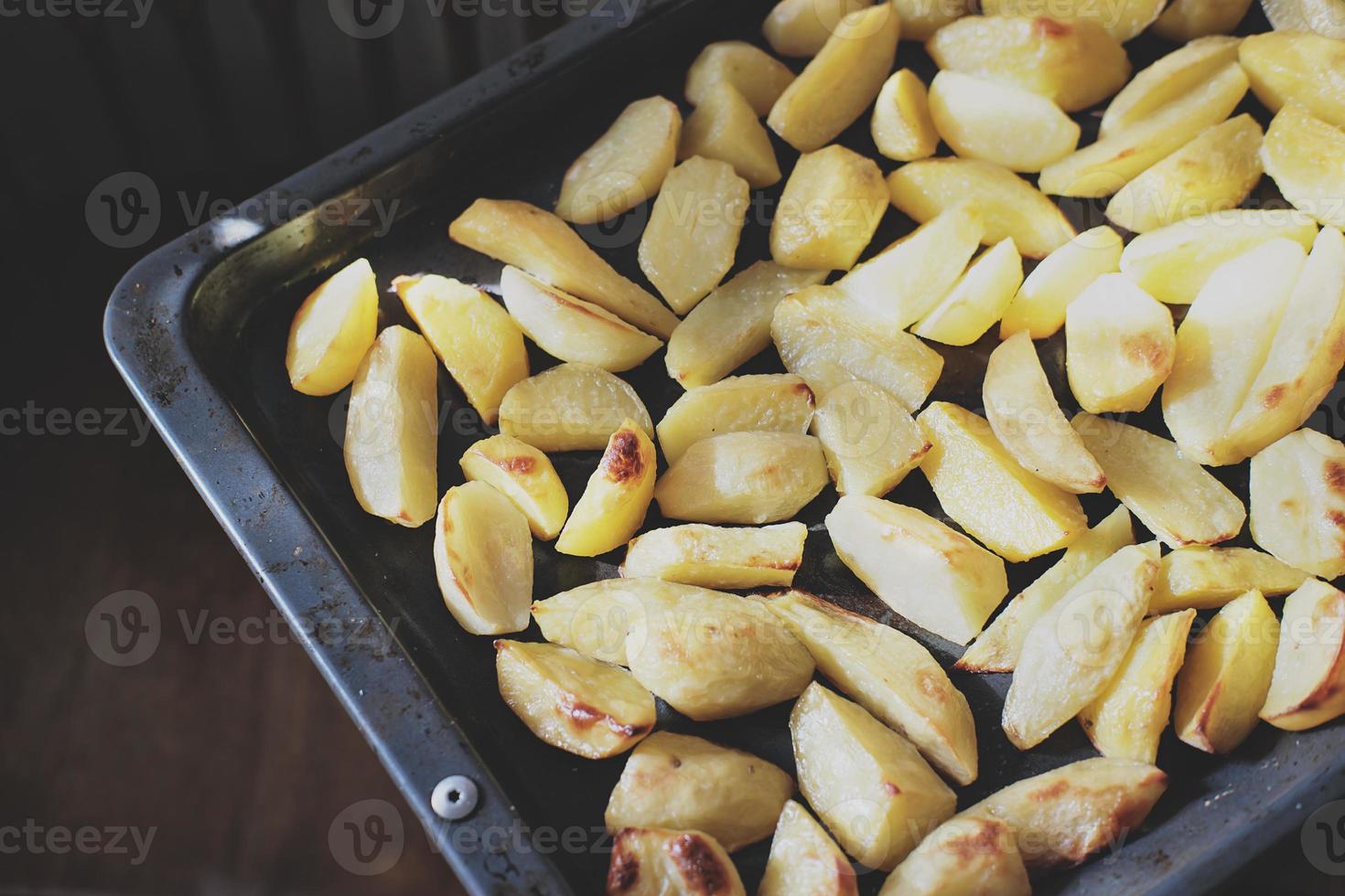 patate al forno croccanti. deliziose patate per la cena casalinga appena sfornate. cena di fine settimana in famiglia foto