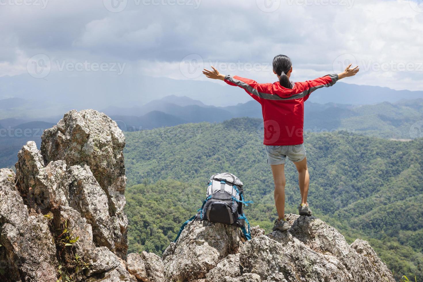 ragazza sulla montagna guarda la bellissima valle nella nebbia d'estate. paesaggio con giovani donne sportive, escursionismo, viaggi e turismo. foto