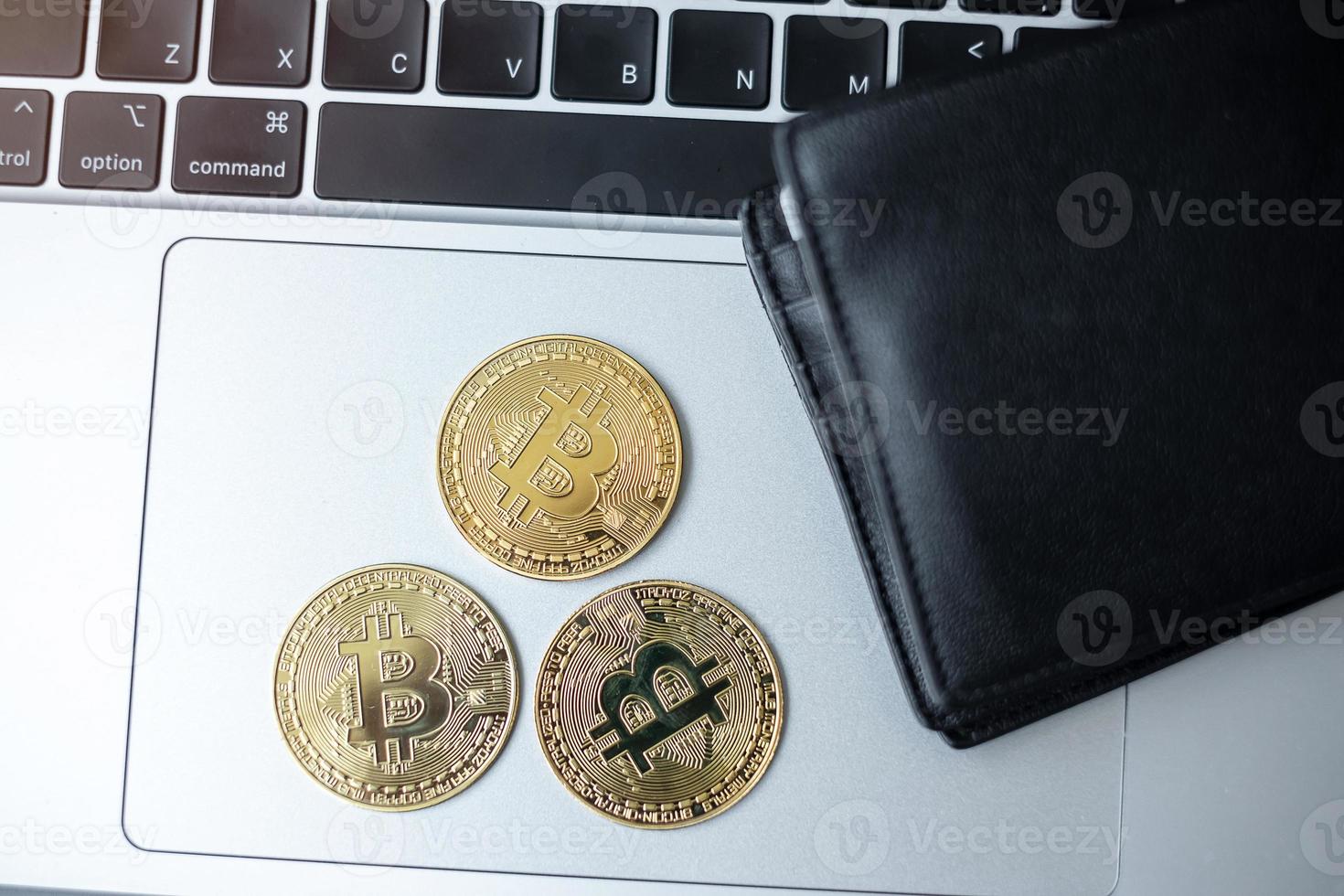 criptovaluta dorata e portafoglio su tastiera portatile, moneta bitcoin. crypto è denaro digitale all'interno della rete blockchain foto