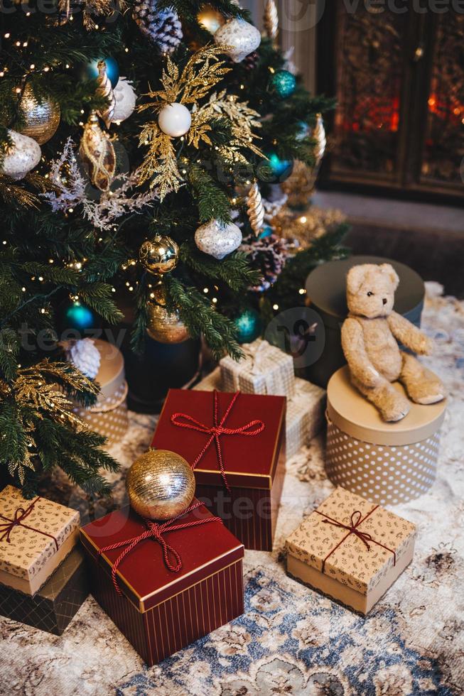 immagine verticale di albero di natale decorato con palline e molti regali sotto l'albero di abete. momenti piacevoli ed evento festivo. composizione del mucchio con doni. vacanze di capodanno. foto