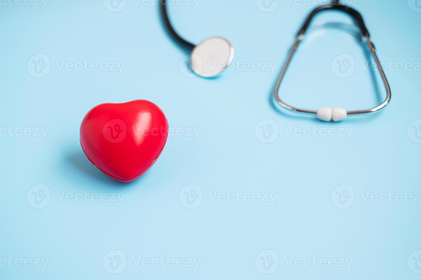 stetoscopio vista dall'alto a forma di cuore rosso su sfondo blu con spazio per la copia del testo. assistenza sanitaria, assicurazione sulla vita, giornata della salute, giornata mondiale del cuore e felice concetto di giornata del medico foto